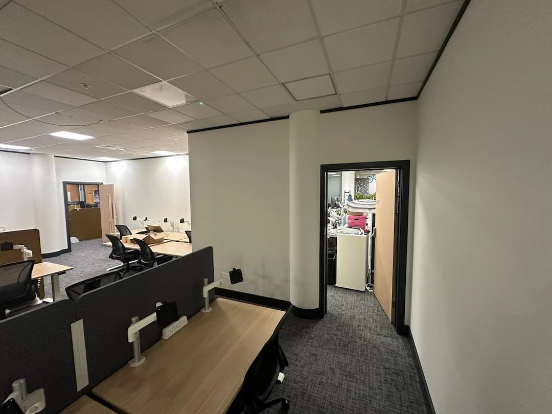 a room with a door open and a desk