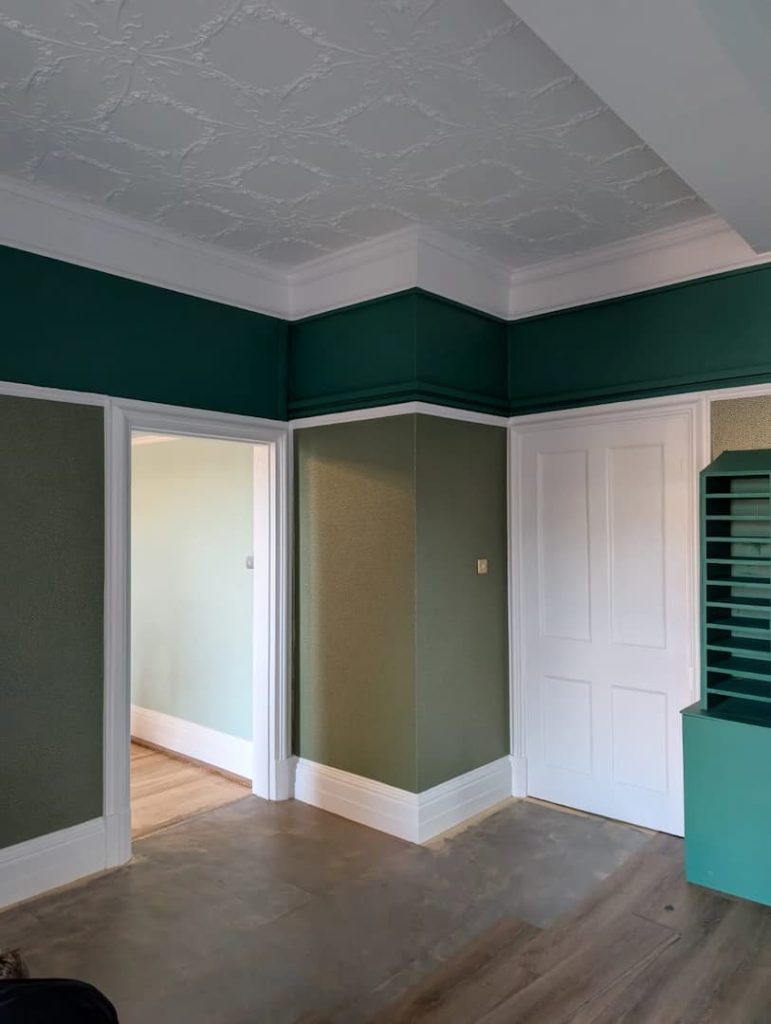 a room with green walls and white doors